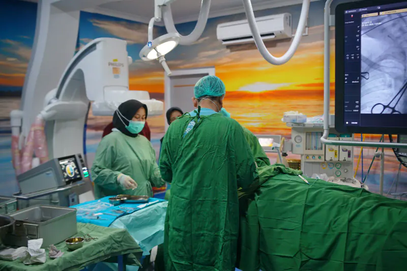 Tim bedah menggunakan C-arm dan pencitraan angiografi untuk bidang vaskular dan endovaskular